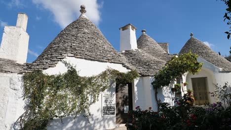 White-houses-with-stone-cone-roofs-in-Monumentale-Trulli,-Alberobello,-Italy