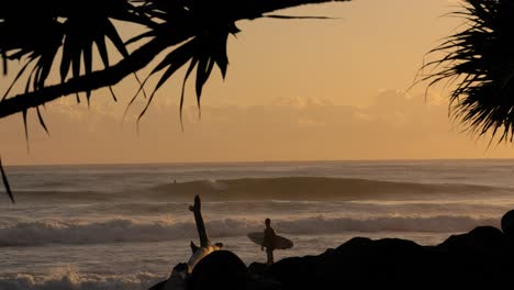 Surfer-waiting-to-enter-the-water-at-Burleigh-Heads,-Gold-Coast,-Australia