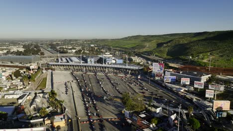 Luftaufnahme-In-Richtung-Der-Einreisehäfen-Der-US-Grenze-San-Ysidro,-Sonniger-Tag-In-Tijuana,-Mexiko