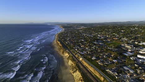 Aerial-view-of-railway-tracks-and-residential-areas-on-the-coast-of-San-Diego,-sunset-in-USA