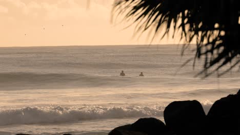 Surfers-waiting-for-waves-at-sunrise-at-Burleigh-Heads,-Gold-Coast,-Australia
