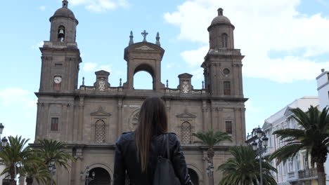 Primer-Plano-De-Una-Mujer-Con-La-Espalda-Admirando-La-Catedral-De-Santa-Ana-En-Las-Palmas,-Gran-Canaria