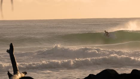 Slow-motion-surfers-at-Burleigh-Heads-at-sunrise-on-the-Gold-Coast,-Queensland,-Australia