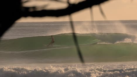 Slow-motion-surfers-at-Burleigh-Heads-at-sunrise-on-the-Gold-Coast,-Queensland,-Australia
