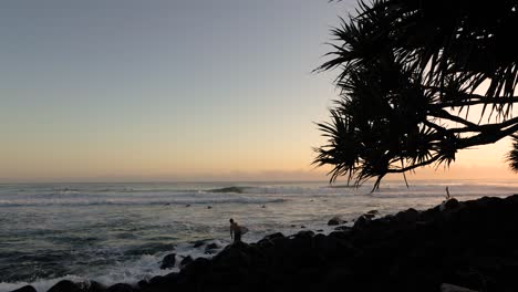 Surfer-entering-the-water-at-Burleigh-Heads-on-the-Gold-Coast,-Queensland,-Australia