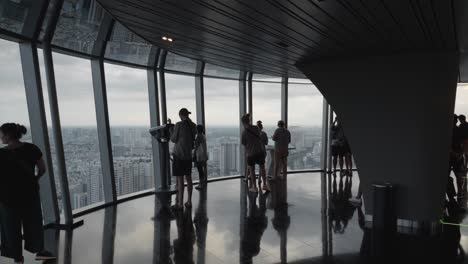 A-view-of-visitors-on-the-observation-deck-of-the-Bitexco-Financial-Tower-in-Ho-Chi-Minh-City,-Vietnam,-enjoying-the-breathtaking-panoramic-views-of-the-cityscape