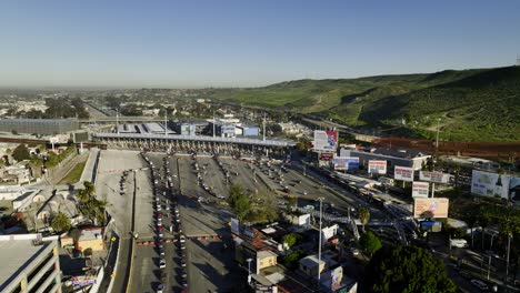 Vista-Aérea-Hacia-El-Puerto-De-Entrada-De-San-Ysidro,-Colas-De-Autos-Cruzando-La-Frontera-En-Tijuana,-México