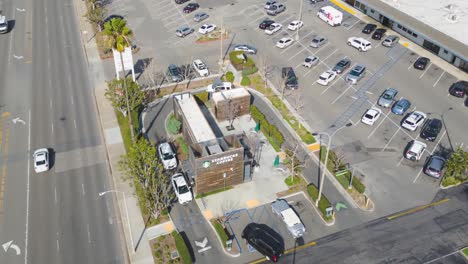 circle-Aerial-drone-time-lapse-captures-a-rare,-unique-prefab-Starbucks-coffee-shop-in-Southern-California,-showcasing-its-innovative-design-hyper-lapse