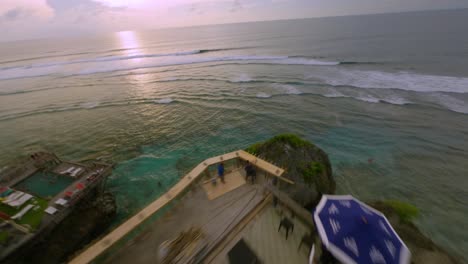 FPV-Drone-shot-of-a-luxurious-holiday-restort-at-the-clear-blue-indian-ocean-during-a-colorful-sunset