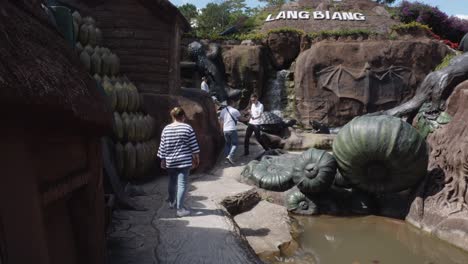 Visitantes-Recorriendo-La-Instalación-De-Arte-Del-Túnel-De-Arcilla-Con-Esculturas-Gigantes-De-Arcilla-En-Da-Lat,-Vietnam