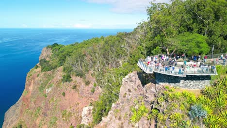 Touristen-Besichtigen-Miradouro-Cabo-Girao-Mit-Dem-Wasser-Des-Atlantischen-Ozeans-Im-Hintergrund-Und-Dem-Grün-Der-Umliegenden-Landschaft