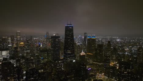 Vista-Aérea-De-La-Torre-John-Hancock,-Noche-Nebulosa-En-Chicago,-Ee.uu.---Tire-Hacia-Atrás,-Tiro-De-Drones