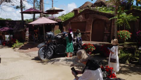 Una-Familia-Vietnamita-Toma-Fotos-En-Una-Escultura-De-Una-Motocicleta-Negra-En-El-Túnel-De-Arcilla-En-Da-Lat,-Vietnam