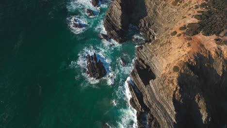 Reefs-of-Atlantic-ocean-in-Portugal,-top-down-drone-aerial-view-of-rough-sea-water-and-rocky-coast