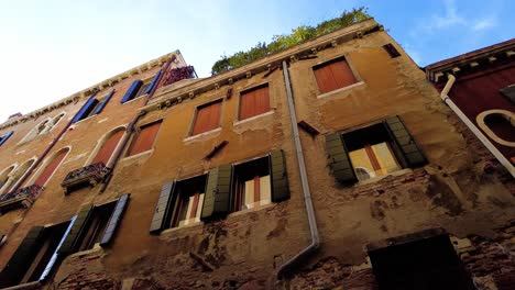 Person's-POV-Looking-Up-At-Old-Facade-Of-Houses-In-Venice,-Italy