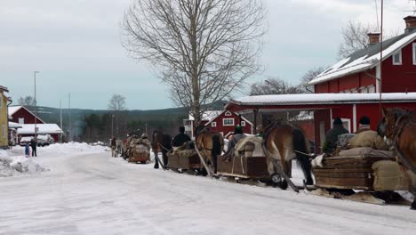People-dressed-in-old-contemporary-cloths-traveling-by-horse-driven-sledges-in-a-winter-landscape