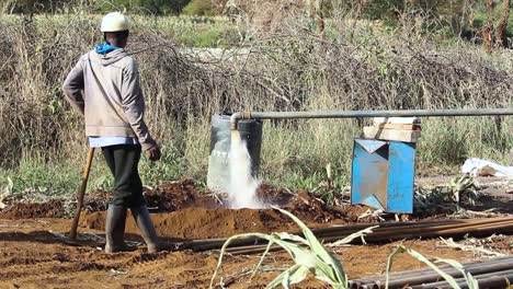 Afrikanischer-Mann-Durch-Wasserversorgung-Aus-Bohrloch-Bohrrohr-In-Kenia-Dorf