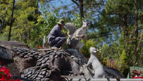 Un-Hombre-Está-Pintando-Cuidadosamente-Una-Estatua-De-Ardilla-En-El-Museo-De-Escultura-Da-Lat-En-Vietnam