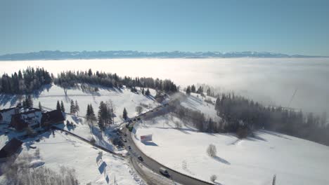 Aerial-Footage-of-Sea-of-Clouds,-Huge-Mountains-Landscape-and-Driving-Cars