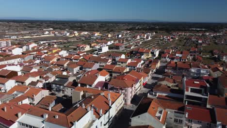 Aerial-flyover-village-of-Praia-de-Mira-with-red-rooftops-during-sunny-day-with-blue-sky-in-Portugal,Europe