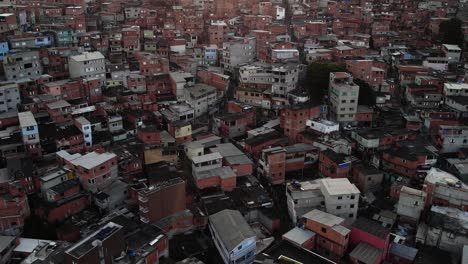 Drone-shot-over-a-poverty-village,-shanty-town-houses,-sunny-evening-in-Brazil