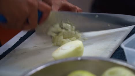 Professional-kitchen-hand-preparing-the-ingredients-for-restaurant-operation,-brunoise-cut-the-onion,-close-up-shot