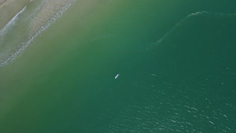 Birds-Eye-view-of-Kayaker-paddling-through-the-blue-waters-in-summer