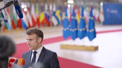 El-Presidente-Francés-Emmanuel-Macron-Hablando-Con-La-Prensa-Con-Las-Banderas-Europeas-Y-Las-Banderas-De-Los-Estados-Miembros-De-La-Ue-En-La-Cumbre-Del-Consejo-Europeo-En-Bruselas,-Bélgica