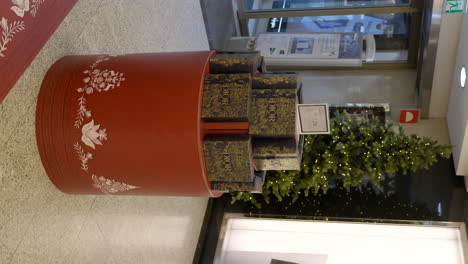 Vertikale-Aufnahme-Eines-Einkaufszentrums-Mit-Rotem-Sockel-Der-Marke-Dior-Als-Weihnachtsdekoration