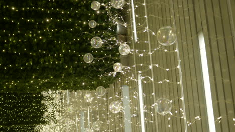 Vertical-shot-of-Christmas-shopping-mall-lights-attached-to-ceiling,-handheld