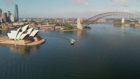Sydney,-New-South-Wales,-Australien---24.-Dezember-2021:-Fähre-Fährt-Um-Das-Sydney-Opera-House-Herum,-Mit-Der-Sydney-Harbour-Bridge-Im-Hintergrund