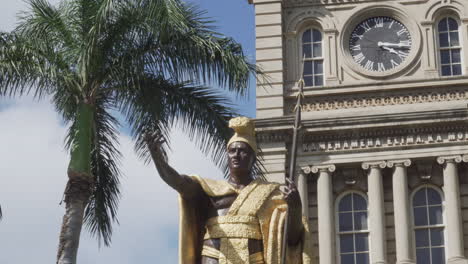 Oberkörperansicht-Der-Statue-Des-Goldkönigs-Kamehameha-Vor-Einem-Gebäude-Und-Palmen-An-Einem-Sonnigen-Tag-In-Honolulu,-Hawaii