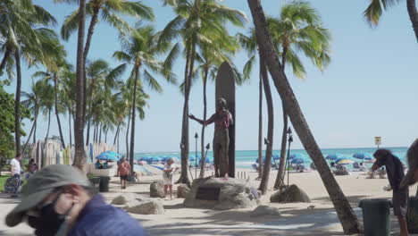 Gente-Y-Turistas-Disfrutando-De-Un-Día-Soleado-Y-Brillante-En-La-Playa-De-Waikiki-En-Hawaii-Cerca-De-La-Estatua-Del-Duque-De-Paoa-Kahanamoku