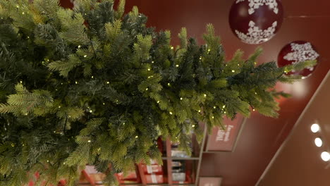 Vertical-video-of-shopping-mall-Christmas-tree-decoration,-interior,-dolly-out