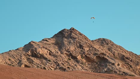 4K:-Paragliders-have-free-flying-over-UAE-mountains,-an-adventure-sports-concept
