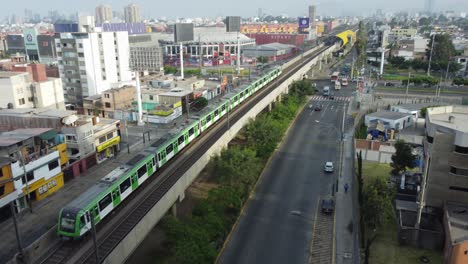 Electrical-train-passes-by-on-a-railway-built-in-the-middle-of-a-2-way-street