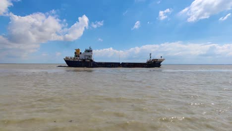 A-large-bulk-cargo-ship-sails-over-the-Padma-river-under-the-blue-sky-with-white-clouds