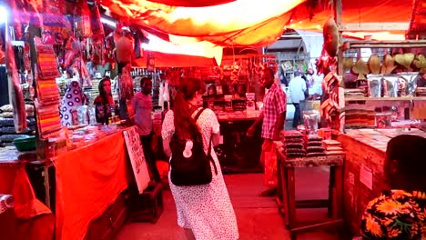 Rear-view-of-white-woman-walking-through-spices-and-fruits-market-in-Marikiti-Kuu,-Zanzibar