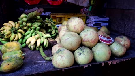Slow-motion-zoom-to-grenade,-bananas-and-cocoa-on-sale-at-street-stall-in-tropical-bazaar-market