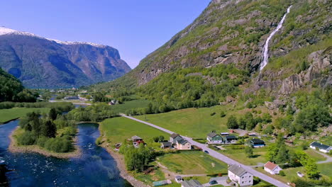 Village-on-river-green-shores-in-summer-season,-Norway