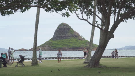 Los-Turistas-Disfrutan-De-Un-Día-Nublado-En-La-Playa-Con-Vistas-A-La-Isla-De-Mokoli&#39;i,-También-Conocida-Como-Sombrero-De-Chino