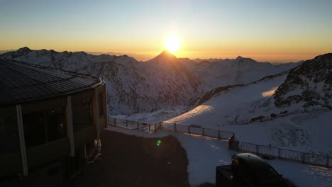 aerial,-sunrise-in-the-alps,-warm-sky-without-cloud,-snowy-mountain-peaks