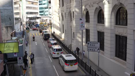 Stadtstraßenverkehr-Mit-Fußgängern-Und-Motorrollern-Im-Städtischen-Stadtzentrum-Von-Hongkong