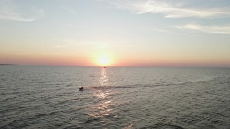 Freizeitaktivität,-Jetski-Auf-Dem-Meerwasser-Bei-Goldorangefarbenem-Sonnenuntergang,-Luftaufnahme
