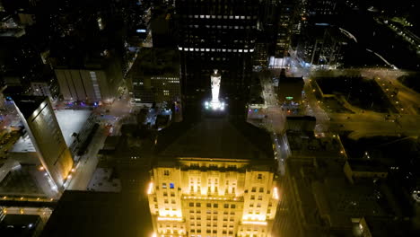 Aerial-view-approaching-towards-the-Ceres-statue-on-top-of-the-illuminated-Board-of-Trade-tower-in-Chicago,-USA