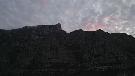 Tiro-De-Drone-Al-Atardecer-De-Nubes-Rosadas-Sobre-La-Montaña-De-La-Mesa-En-Ciudad-Del-Cabo,-Sudáfrica