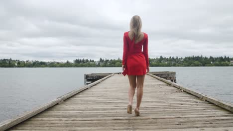 Blonde-Model-Frau-Im-Roten-Kleid,-Die-Auf-Einem-Pier-Läuft