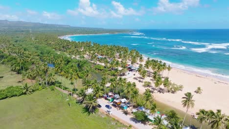 Aerial-wide-shot-showing-tropical-paradise-with-palm-trees,-Caribbean-sea-and-golden-beach-in-summer---ARROYO-SALADO,-CABRERA,-DOMINICAN-REPUBLIC