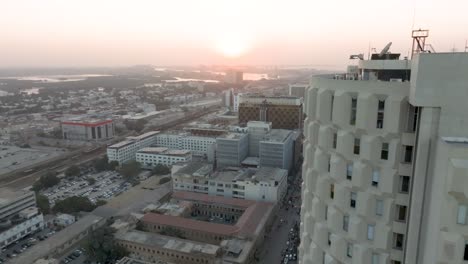 Vuelo-Aéreo-Más-Allá-De-La-Plaza-Del-Banco-Habib-En-Karachi-Contra-El-Cielo-Anaranjado-Del-Atardecer