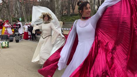 Two-young-women-dressed-as-fairies-with-wings-dancing-and-rehearsing-performance-happily-for-carnival